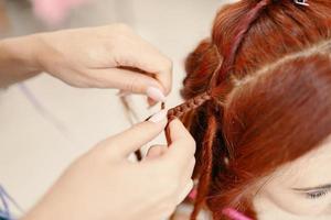 gros plan du processus de tressage des tresses africaines avec du kanekalon coloré. photo