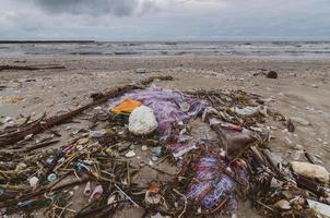 ordures la bouteille en plastique de mer de plage se trouve sur la plage et pollue la mer et la vie de la vie marine a renversé des ordures sur la plage de la grande ville. bouteilles en plastique sales vides utilisées photo