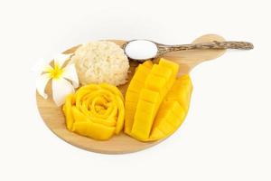 Riz gluant à la mangue avec fleur sur une plaque en bois sur fond blanc
