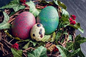 oeufs de pâques avec décoration.oeufs de caille et de poule dans un nid d'oiseaux. photo
