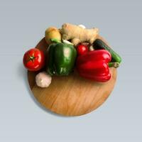 un unique concept de des légumes sur en bois arrondi table isolé sur gris. photo