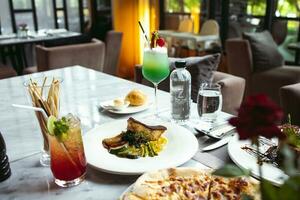 luxe table réglages pour bien à manger servi et décoré table avec nourriture pour invités dans le restaurant photo