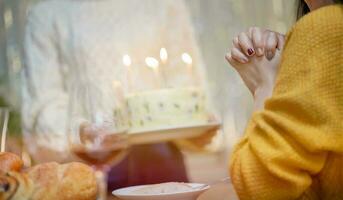 de bonne humeur copains profiter Accueil anniversaire vacances faire la fête. asiatique sœur applaudissement en buvant rouge du vin célébrer avec anniversaire gâteau. photo