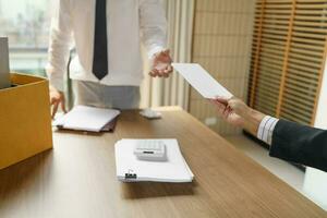 quitter emploi affaires homme Envoi en cours démission lettre et emballage des trucs démissionner déprimer ou porter affaires papier carton boîte dans bureau. changement de emploi ou mis à la porte de entreprise. photo