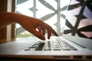 travail par en utilisant une portable ordinateur sur en bois tableau. mains dactylographie sur une clavier. photo