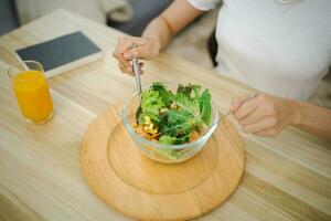 asiatique femme suivre un régime poids perte en mangeant Frais Frais fait maison salade en bonne santé en mangeant concept photo