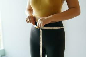 femme vouloir à perdre poids avec une centimètre forme en haut en bonne santé estomac muscle et régime mesure taille avec mesure ruban après régime poids contrôle photo