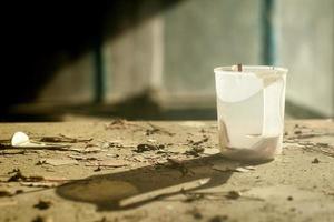 Une image de nature morte avec une vieille tasse en plastique sur une table dévastée photo