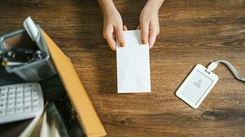 affaires femme Envoi en cours démission lettre et emballage des trucs démissionner déprimer ou porter affaires papier carton boîte par bureau dans bureau. changement de emploi ou mis à la porte de entreprise photo