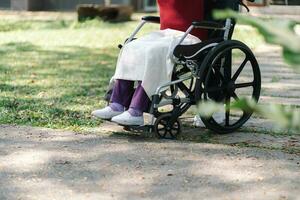 allaitement maison. Jeune soignant portion Sénior femme dans fauteuil roulant. photo