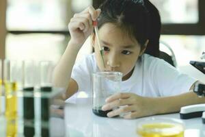 peu enfant avec apprentissage science classe dans école laboratoire photo