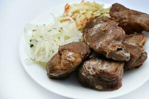 magnifique frit pièces de porc Viande. porc kebab avec des légumes. Viande sur une plaque. photo