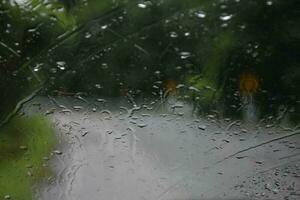 flou image de gouttes de pluie sur le arrière vue miroir de voiture, doux concentrer photo