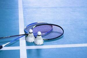 volant de badminton blanc crème et raquette au sol dans un terrain de badminton intérieur, espace de copie, mise au point douce et sélective sur les volants. photo