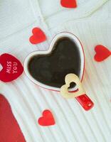rouge tasse de thé dans le forme de cœur avec une biscuit photo