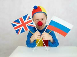 en colère garçon garde deux drapeaux de le Royaume-Uni et Russie photo