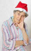 vieux femme dans le chapeau de une Père Noël claus photo