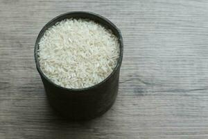 blanc riz, riz dans le le fer récipient sur le en bois Contexte photo