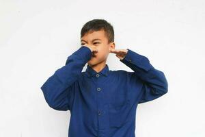 enfant en portant le sien nez, odeur mal odeur isolé sur blanc photo