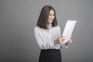 femme d'affaires en chemise blanche sur fond gris photo