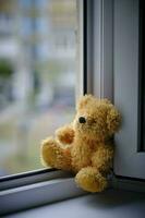 ours enfants doux jouet séance bord un ouvert fenêtre.concept les accidents avec les enfants. photo