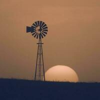 Moulin à vent dans campagne à coucher de soleil, pampa, Patagonie, Argentine. photo