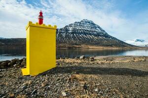 un iconique Jaune phare dans de face de Holmatindur Montagne dans eskifjordur ville de est Islande. photo