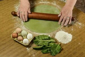 de grand-mère mains pétrissage, pâte pour vert nouilles. photo