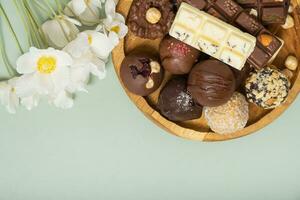 en bois assiette avec en bonne santé artisanat Naturel des sucreries et mini des chocolats. sucré nourriture, en bonne santé dessert photo