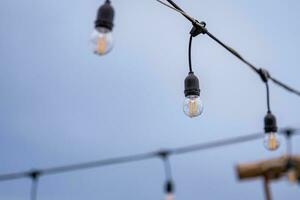 Célibataire lumière ampoule sur une corde dans le pluie photo