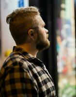 homme à la recherche à magasin fenêtre dans soir rue - boutique et Shopaholic consumérisme concept photo