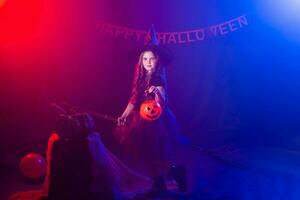 marrant enfant fille dans sorcière costume pour Halloween avec citrouille jack. photo