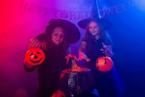 deux Halloween sorcières fabrication une potion et conjurer dans Halloween nuit. la magie, vacances et mystique concept. photo