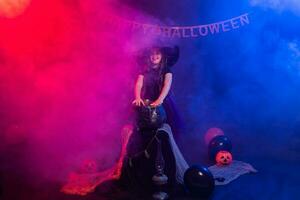 marrant enfant fille dans sorcière costume pour Halloween avec citrouille jack. photo