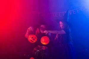 deux Halloween sorcières fabrication une potion et conjurer dans Halloween nuit. la magie, vacances et mystique concept. photo