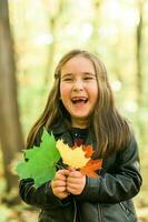 l'automne émotif portrait de en riant enfant en marchant dans parc ou forêt photo