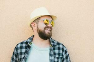 barbu homme portrait dans été vêtements et chapeau supporter plus de beige mur sur rue ville Urbain et Voyage concept - copie espace et vide espace pour La publicité photo