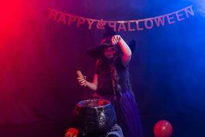 marrant enfant fille dans sorcière costume pour Halloween avec citrouille jack. photo