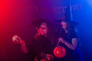 deux Halloween sorcières fabrication une potion et conjurer dans Halloween nuit. la magie, vacances et mystique concept. photo