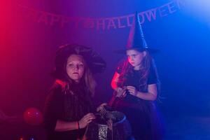 marrant enfant fille et femme dans sorcières costumes pour Halloween avec citrouille jack. photo