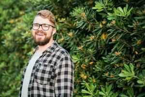 proche en haut portrait Beau Jeune homme plus de vert buisson à l'extérieur copie espace et endroit pour publicité. photo