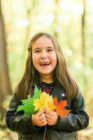 l'automne émotif portrait de en riant enfant en marchant dans parc ou forêt photo