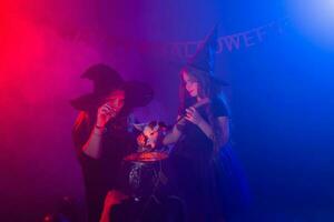 marrant enfant fille et femme dans sorcières costumes pour Halloween avec chien. photo