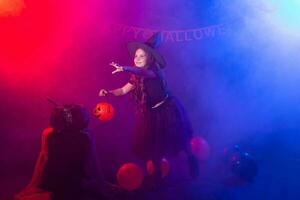 marrant enfant fille dans sorcière costume pour Halloween avec citrouille jack. photo