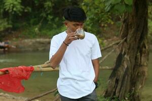 gorontalo- Indonésie - 09 juin 2023 - Jeune homme profiter le sien vacances dans le parc dans le Matin photo