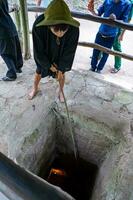 cu chi, viet nam - 20 mai 2023 le cu chi tunnels. une guider démontrant Comment une vietcong cacher dans le tunnel. c'est utilisé dans vietnam guerre. célèbre touristique attraction dans vietnam. Stock photo