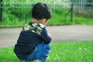 mignonne asiatique pakistanais bébé est profiter le magnifique ensoleillé journée à mise en garde les enfants et Publique parc de luton ville de Angleterre Royaume-Uni. faible angle image a été capturé sur avril 03ème, 2023 photo