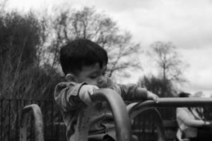 mignonne asiatique pakistanais bébé est profiter le magnifique ensoleillé et du froid journée à mise en garde Publique parc de luton ville de Angleterre Royaume-Uni. faible angle je photo