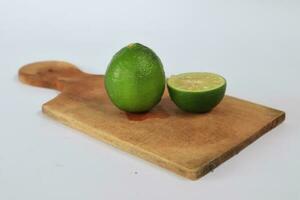 une tranché citron vert sur une Coupe planche sur une blanc Contexte photo