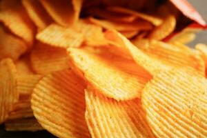 croustilles de pommes de terre dans un sac ouvert, délicieux assaisonnement pour barbecue épicé pour les frites, collations frites en tranches fines de restauration rapide. photo